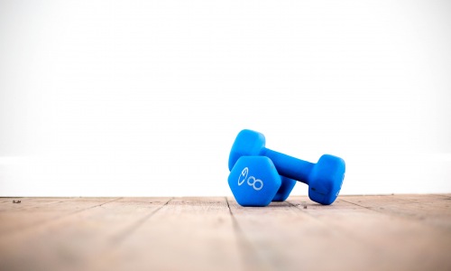 two weights stacked on top of wood floor white background