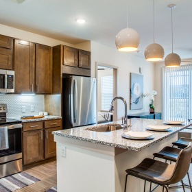 Open Floor Plan Layout pendant lights over kitchen island in senior luxury apartments